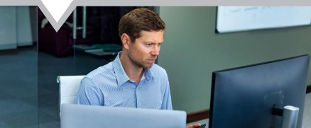 Confident young man businessman broker agent using mobile phone and pc computer