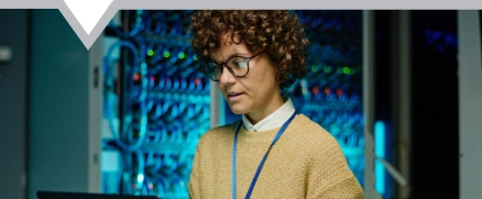 Female executive with headset using computer at desk helping clients with IT solutions