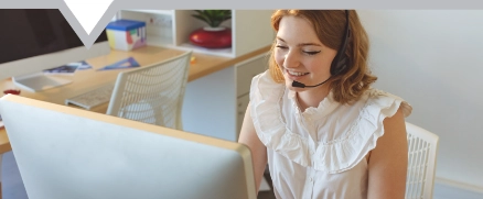 talking on headphone while working on computer at desk